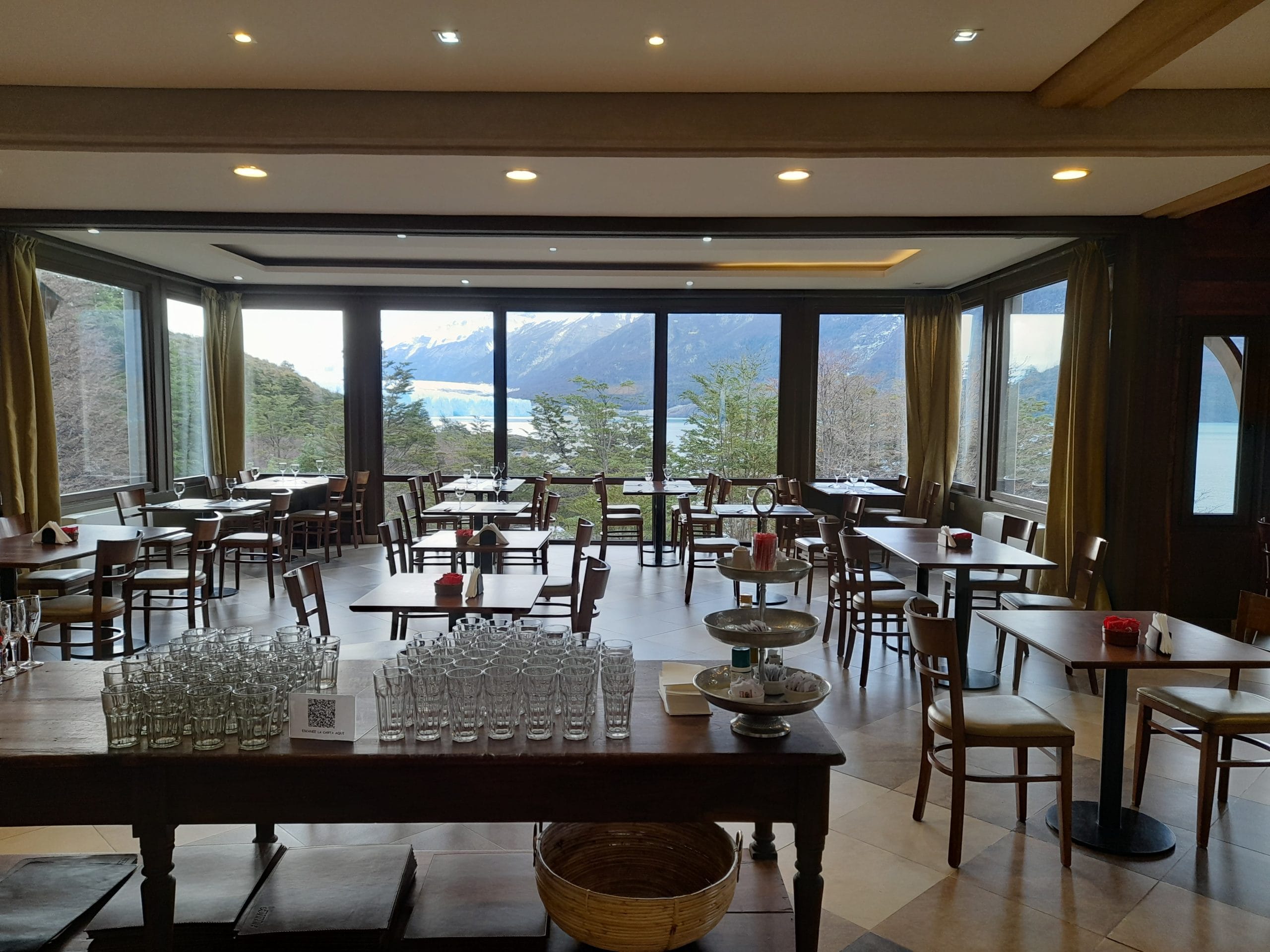 Salón principal del Restó del Glaciar con ventanales hacia la bahía y el glaciar